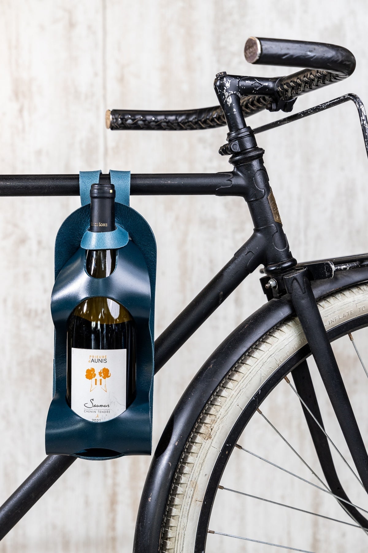 Porte-bouteille en cuir La Bouclée, fabriqué en France, accroché à un vélo