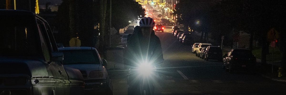 Cycliste de nuit en ville avec un éclairage avant NiteRider allumé