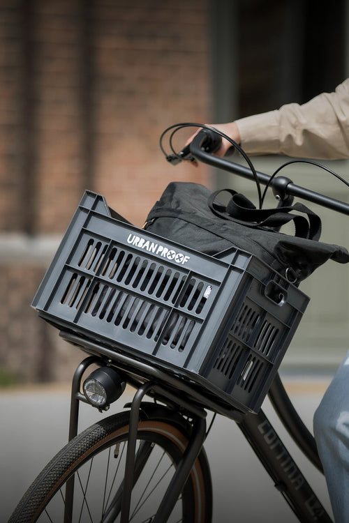 Caisse vélo Urban Proof 30L recyclée sur le porte-bagages avant, à vélo en ville