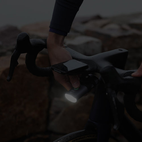 Phare vélo iGPSPORT VS1800S monté sous un compteur GPS, à la tombée de la nuit