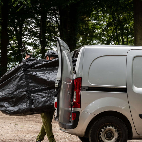 Vélo emballé dans la housse BikeParka RoughSac chargé dans un utilitaire