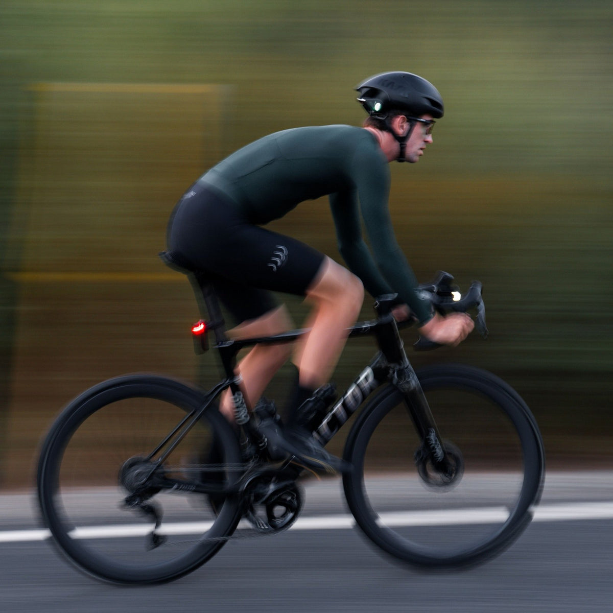 Cycliste sur route avec une lampe avant Ravemen allumée au guidon
