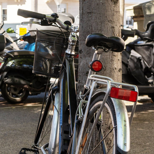 Traceur GPS vélo et trottinette Invoxia sur un vélo de ville garé