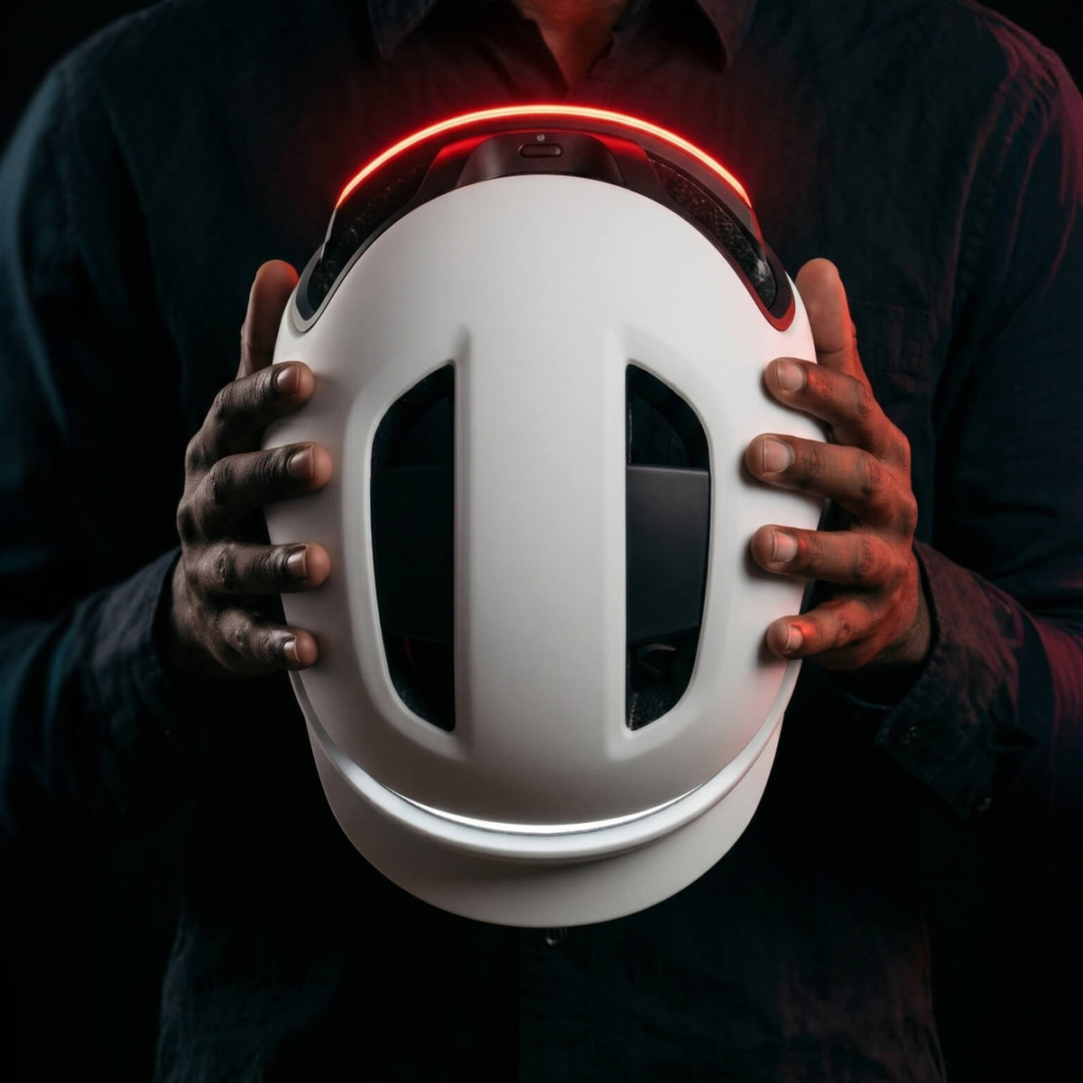 Casque connecté Unit 1 tenu à deux mains, éclairage allumé