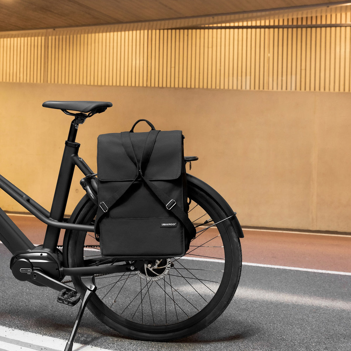 Sac à dos vélo Urban Proof City accroché au porte-bagages d'un vélo en ville